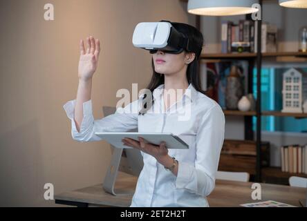 Woman wearing VR glasses in home. Stock Photo
