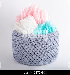 gray handmade basket with colored washcloths. texture of knitted fabric braids Stock Photo