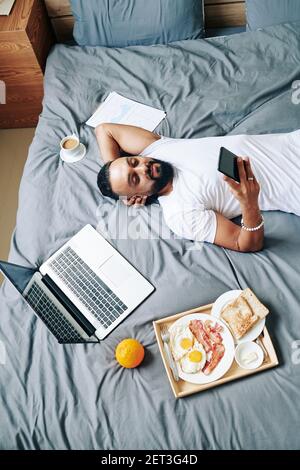 Man resting on bed Stock Photo