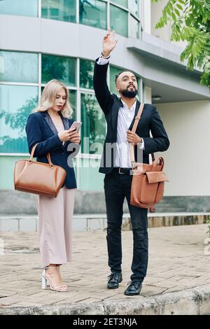 Business couple catching taxi Stock Photo