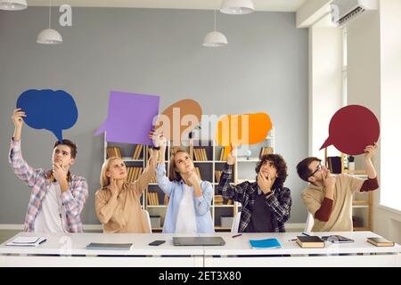 Puzzled college students holding thought bubbles and thinking of answer to test paper Stock Photo