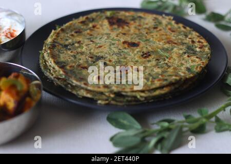 Whole wheat methi thepla rolls with paneer capsicum filling and a bowl of masala curd. A healthy, flavourful , tasty flat bread made of whole wheat, s Stock Photo