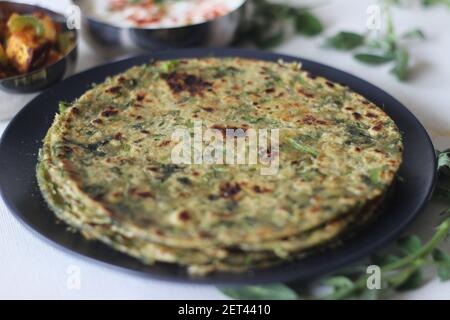 Whole wheat methi thepla rolls with paneer capsicum filling and a bowl of masala curd. A healthy, flavourful , tasty flat bread made of whole wheat, s Stock Photo