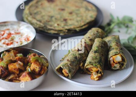 Whole wheat methi thepla rolls with paneer capsicum filling and a bowl of masala curd. A healthy, flavourful , tasty flat bread made of whole wheat, s Stock Photo