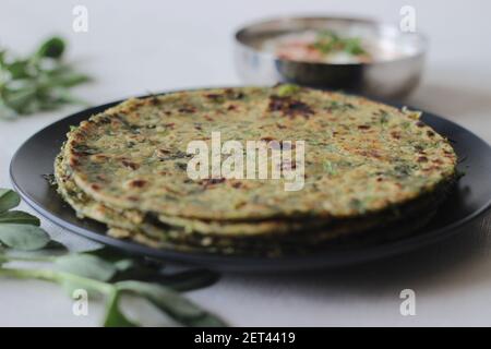 Whole wheat methi thepla rolls with paneer capsicum filling and a bowl of masala curd. A healthy, flavourful , tasty flat bread made of whole wheat, s Stock Photo