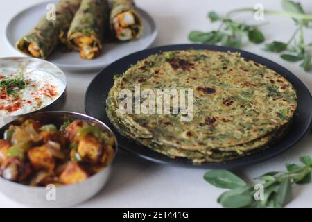 Whole wheat methi thepla rolls with paneer capsicum filling and a bowl of masala curd. A healthy, flavourful , tasty flat bread made of whole wheat, s Stock Photo