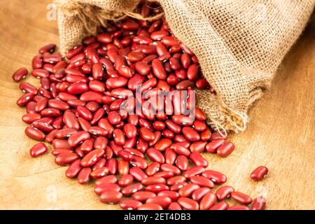 Brown paper bag full of a pile of raw red kidney beans Stock Photo by  wirestock