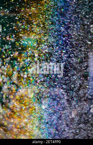 Abstraction, blurred rainbow in water drops. Natural background or texture. splashing water in the sun creates a rainbow color. Stock Photo