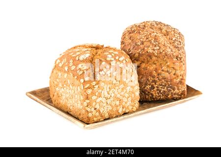 Wholegrain bread buns with seeds and oat on wooden tray isolated on white background. Stock Photo