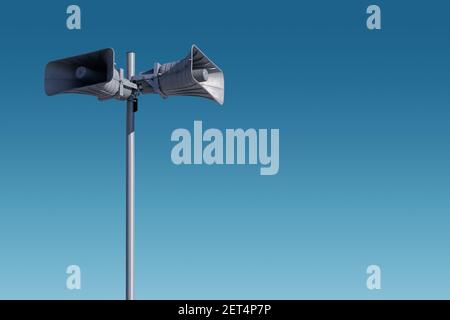 A tall column with two gray speakers against the sky. The system of general warning of the population about the danger. Possibility to post your test Stock Photo