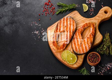 Fresh cooked delicious salmon steak with spices and herbs baked on a grill. Healthy seafood food Stock Photo