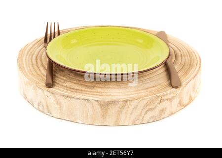 Green plate with knife and fork on wooden board isolated on white background. Stock Photo