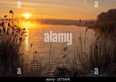 sunrise over the lake on a frosty and misty morning Stock Photo