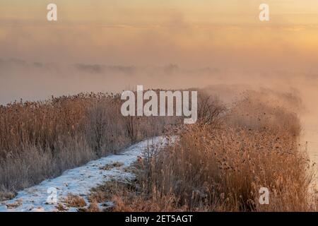 sunrise over the lake on a frosty and misty morning Stock Photo