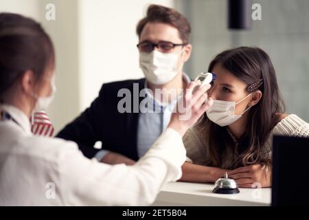 Adult couple wearing masks checking-in a hotel Stock Photo