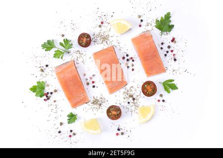 Three fillets of fresh raw salmon fish with spices and aromatic herbs on white background. Top view. Stock Photo