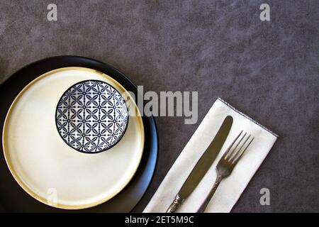 A closeup top view of an empty tableware setting with vintage cutlery on a white napkin Stock Photo