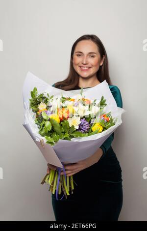 Colorful flowers bouquet in beautiful woman hands on white background Stock Photo