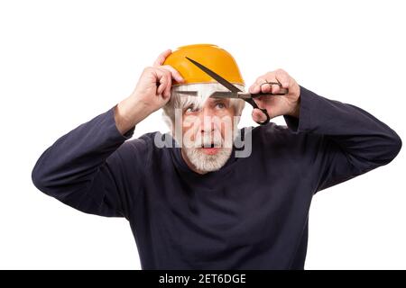 Horizontal shot of an old man giving himself a haircut using a yellow bowl on his head during the pandemic.  White background. Stock Photo