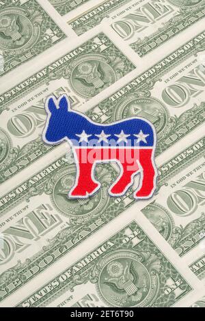 Democrat donkey logo patch badge & US $1 dollar banknotes. For US political fundraising & Democrat campaign funds, Biden debt pile, small $ donors Stock Photo