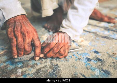 Closeup of hand cutting carpet with scissors. Carpet cleaning service Stock Photo