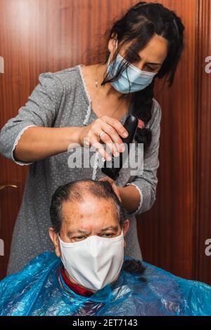 Daughter cutting her father's hair at home Stock Photo