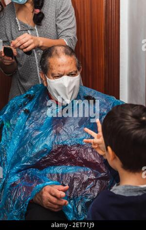 Daughter cutting her father's hair at home Stock Photo