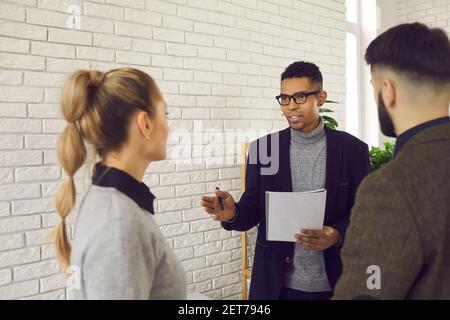 Confident dark skinned businessman explains something important to his colleagues in the office. Stock Photo