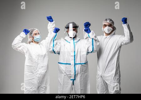 Three healthcare workers make win gesture wearing in hazard isolated on white background Stock Photo