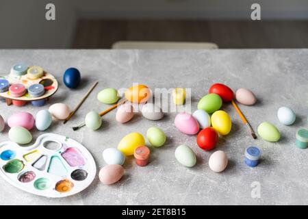 A mother, father and their child painting eggs. Happy family preparing for Easter Stock Photo