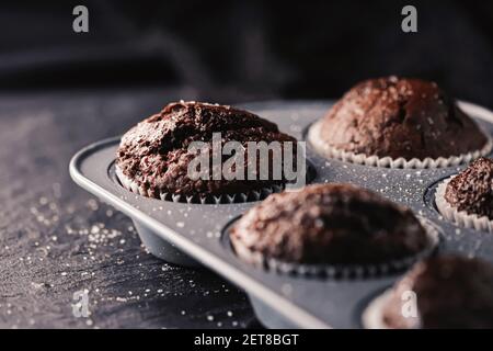 Just baked chocolate muffins in tray, homemade comfort food recipe concept Stock Photo