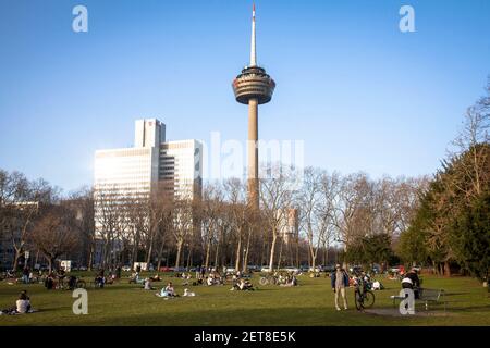 people enjoying an exceptionally warm day on February 24th. 2021 in the park Innerer Gruenguertel, Colonius television tower, Cologne, Germany.  Mensc Stock Photo