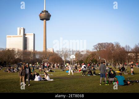 people enjoying an exceptionally warm day on February 24th. 2021 in the park Innerer Gruenguertel, Colonius television tower, Cologne, Germany.  Mensc Stock Photo