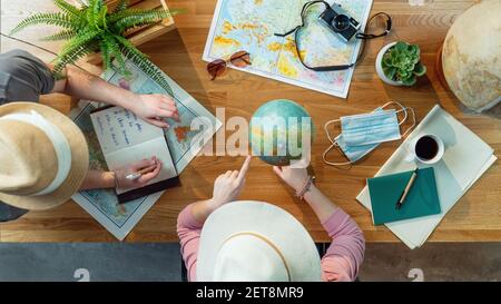 Top view of young couple with maps planning vacation trip holiday, desktop travel concept. Stock Photo