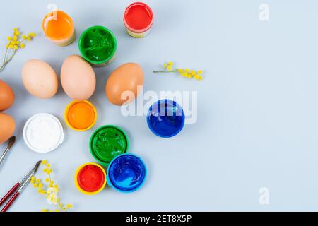 Eggs and paints. Easter eggs decoration process. Copy space. Top view. Stock Photo