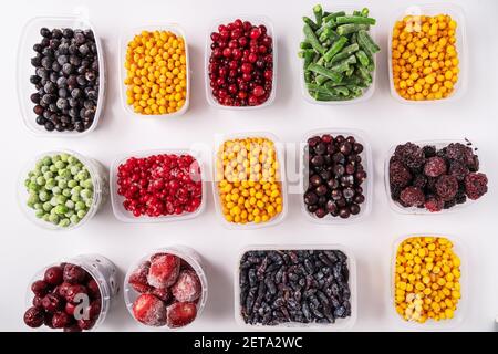 Frozen berries and vegetables in plastic boxes isolated on white background Stock Photo