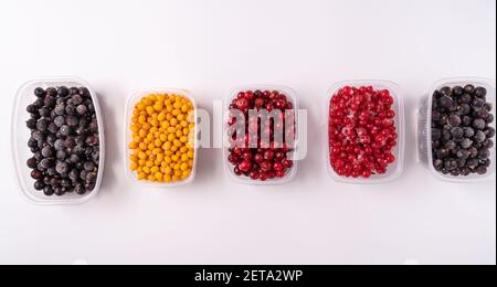 Frozen berries in plastic boxes isolated on white background Stock Photo
