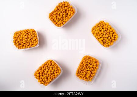 Frozen berries of buckthorn in plastic boxes isolated on white background Stock Photo