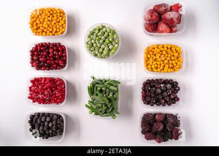 Frozen berries and vegetables in plastic boxes isolated on white background Stock Photo