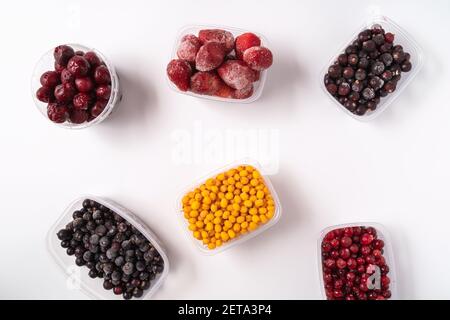 Frozen berries in plastic boxes isolated on white background Stock Photo