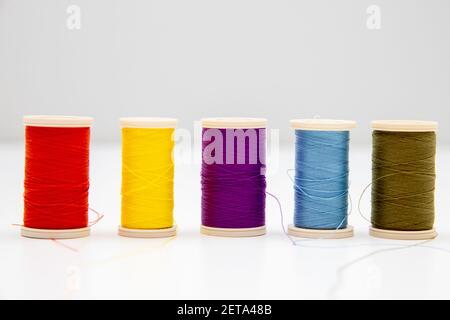 Five multi-colored thread spools isolated in the light background Stock Photo
