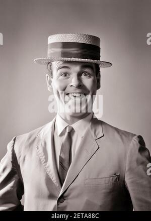 1960s LAUGHING MAN IN STRAW BOATER HAT AND SUMMER SUIT AND TIE WITH ENTHUSIASTIC SILLY FACIAL EXPRESSION LOOKING AT CAMERA - bs00433 CAM001 HARS PERSONS CHARACTER MALES B&W EYE CONTACT BUG-EYED SUIT AND TIE HUMOROUS HAPPINESS EXCITEMENT CAM001 ZANY COMICAL PRIDE ENTHUSIASTIC COMEDIAN OPEN MOUTH NECKTIE COMEDY JOYFUL STYLISH WACKY WIDE EYED STORY MAN EXAGGERATED MID-ADULT MID-ADULT MAN BLACK AND WHITE CAUCASIAN ETHNICITY OLD FASHIONED OLD-FASHIONED Stock Photo