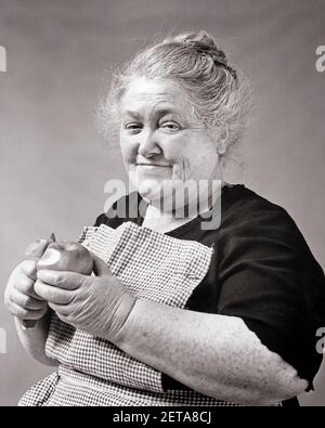 1930s 1940s SMILING SENIOR WOMAN CHARACTER WEARING APRON PEELING APPLE GRAY HAIR TOPKNOT IRISH DOMESTIC WORKER LOOKING AT CAMERA - c1876 HAR001 HARS GRANDPARENTS IRISH PLEASED JOY LIFESTYLE SATISFACTION ELDER FEMALES GRANDPARENT JOBS POOR HEALTHINESS HOME LIFE COPY SPACE FRIENDSHIP HALF-LENGTH LADIES PERSONS WISE CARING CHARACTER SERENITY SENIOR ADULT B&W EYE CONTACT SENIOR WOMAN HOMEMAKER SKILL OCCUPATION HAPPINESS SKILLS HOMEMAKERS WELLNESS OLDSTERS CHEERFUL OLDSTER STRENGTH LEADERSHIP POWERFUL PRIDE GRANDMOTHERS HOUSEWIVES OCCUPATIONS SMILES ELDERS CONCEPTUAL JOYFUL STYLISH PEELING Stock Photo