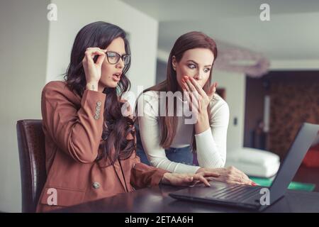 Young Caucasian surprised women watching something in the laptop Stock Photo