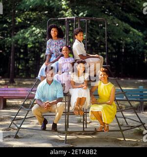 1980s FAMILY PORTRAIT AFRICAN-AMERICAN MOTHER FATHER AND 4 CHILDREN A BOY AND THREE GIRLS SITTING ON PLAYGROUND MONKEY BARS - kj9411 TEU001 HARS PLAYGROUND MOM NOSTALGIC PAIR 4 COMMUNITY COLOR MOTHERS OLD TIME NOSTALGIA OLD FASHION 1 JUVENILE SONS PLEASED FAMILIES JOY LIFESTYLE FEMALES MARRIED SPOUSE HUSBANDS HEALTHINESS 6 FRIENDSHIP LADIES DAUGHTERS PERSONS MALES TEENAGE GIRL SIX FATHERS PARTNER HAPPINESS WELLNESS CHEERFUL AFRICAN-AMERICANS AFRICAN-AMERICAN AND DADS BLACK ETHNICITY PRIDE SMILES CONNECTION JOYFUL JUVENILES MOMS PRE-TEEN PRE-TEEN BOY PRE-TEEN GIRL TOGETHERNESS WIVES MONKEY BARS Stock Photo