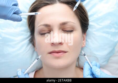 Portrait of woman with closed eyes being given multiple beauty injections Stock Photo