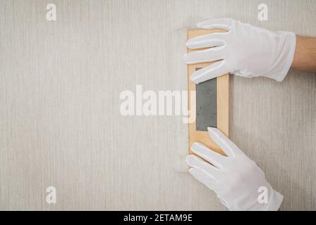 Adhesive Wallpaper Glue Applying Using Roller Close Up Photo. Worker  Installing New Modern Vinyl Wallpapers Stock Photo - Alamy