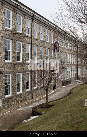Large renovated buildings along the Lamprey River in downtown Newmarket, NH. Apartments, yoga studio, restaurant, ice cream shop, a bike manufacturing Stock Photo