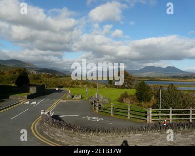 An asphalt road for cars and bicycles surrounded by grass and bushes in Wales Stock Photo