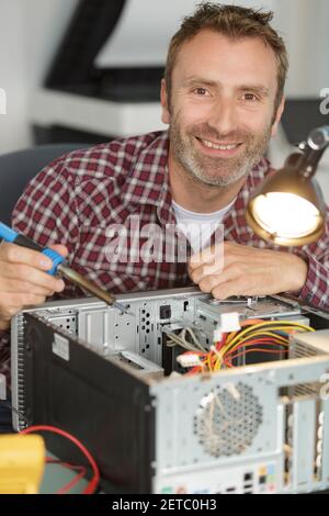 happy man fixes a pc Stock Photo
